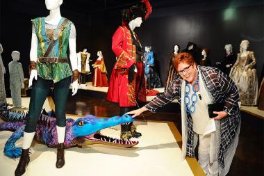Television Academy governor Sue Bub meets a croc from Peter Pan Live! at The 9th Annual Outstanding Art of Television Costume Design Exhibition at the FIDM Museum & Galleries, Saturday, July 18, 2015, in Los Angeles. 