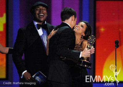 Actor Jim Parsons (C) accepts his award from actors L.L. Cool J (L) and Eva Longoria Parker onstage at the 62nd Annual Primetime