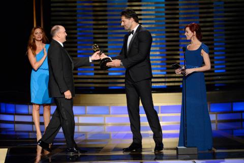 The Blacklist stunt coordinator Cort L. Hessler III (l) accepts an award from Joe Manganiello (c) and Carrie Preston (r) at the 2014 Primetime Creative Arts Emmys.