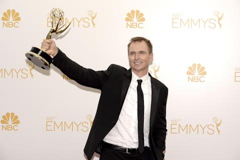 Phil Keoghan of The Amazing Race celebrates at the 66th Emmys. 