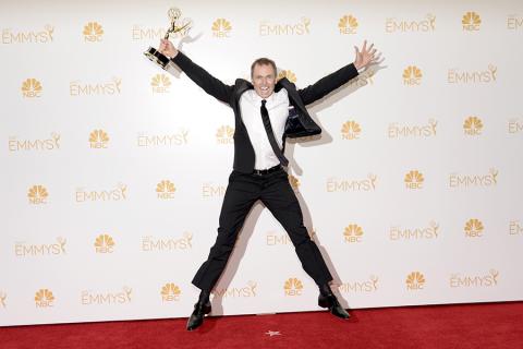 The Amazing Race producer Phil Keoghan celebrates his win at the 66th Emmy Awards.