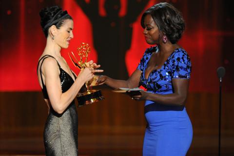 Julianna Margulies (l) of The Good Wife accepts an award from Viola Davis at the 66th Emmy Awards.