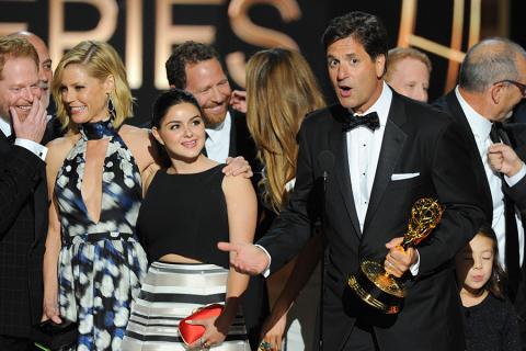Steven Levitan (r) and the cast and producers of Modern Family accept an award at the 66th Emmy Awards.