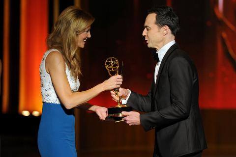 Anna Gunn (l) of Breaking Bad accepts an award from Jim Parsons of The Big Bang Theory at the 66th Emmy Awards.