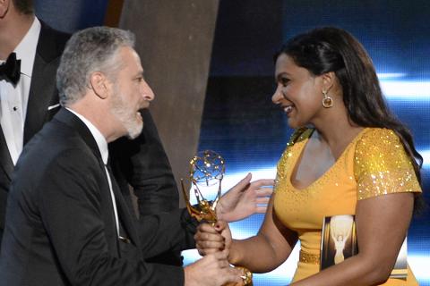 Jon Stewart accepts his award from Mindy Kaling at the 67th Emmy Awards.