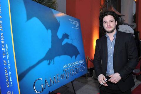 Kit Harrington signs a poster at An Evening with Game of Thrones. 
