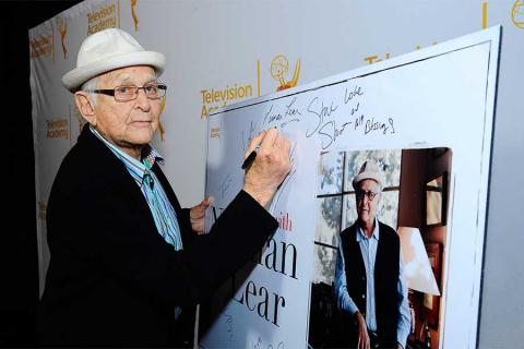 Norman Lear signs the poster at An Evening with Norman Lear at the Montalban Theater in Hollywood.