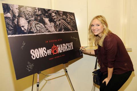 Panel moderator Meg Masters signs the poster at An Evening with Sons of Anarchy.